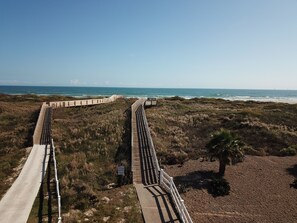 Eine Küstenpromenade mit freiem Blick auf das Meer und den Strand.