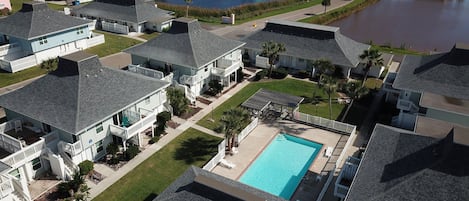 A coastal residential area with houses, a swimming pool, and a view of the ocean.