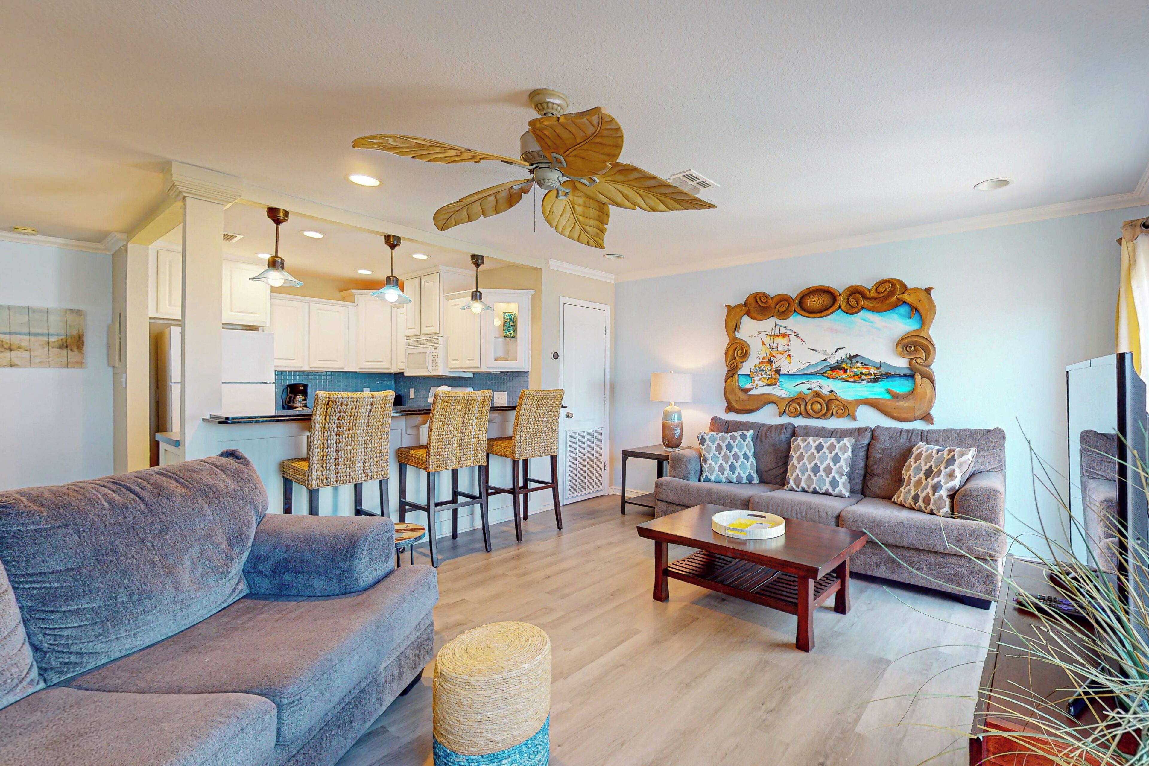 A spacious living area with a sofa, a coffee table, and a dining area with chairs.