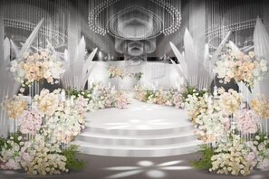 Un escenario con un fondo blanco y arreglos florales.