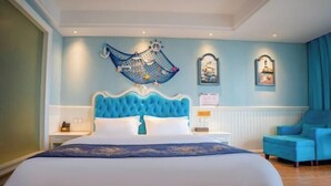 Un dormitorio con una cama grande, una silla y obras de arte en las paredes.