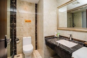 Un baño con inodoro, lavamanos, espejo y ducha.