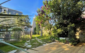 A wooden deck with a stone pathway leading to a house. - "La Boétie II" - 50 m2 de Charme Limoges Centre (Limoges)