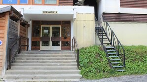 A building entrance with a sign reading "PELVOUX I" and a staircase leading up to it.