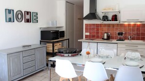 A modern kitchen with white cabinets, a black stove, and a tiled backsplash.