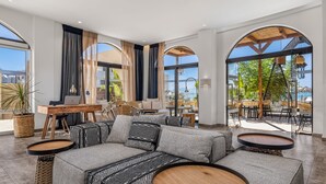 A modern lounge area with a sofa, round tables, and a view of the outdoors. - Cabana Blu Hotel & Suites (Kos)