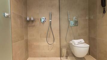Un bagno moderno con doccia a pavimento, un water e un portasciugamani.