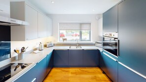 Una cucina moderna con forno integrato, lavello e finestra vista strada.