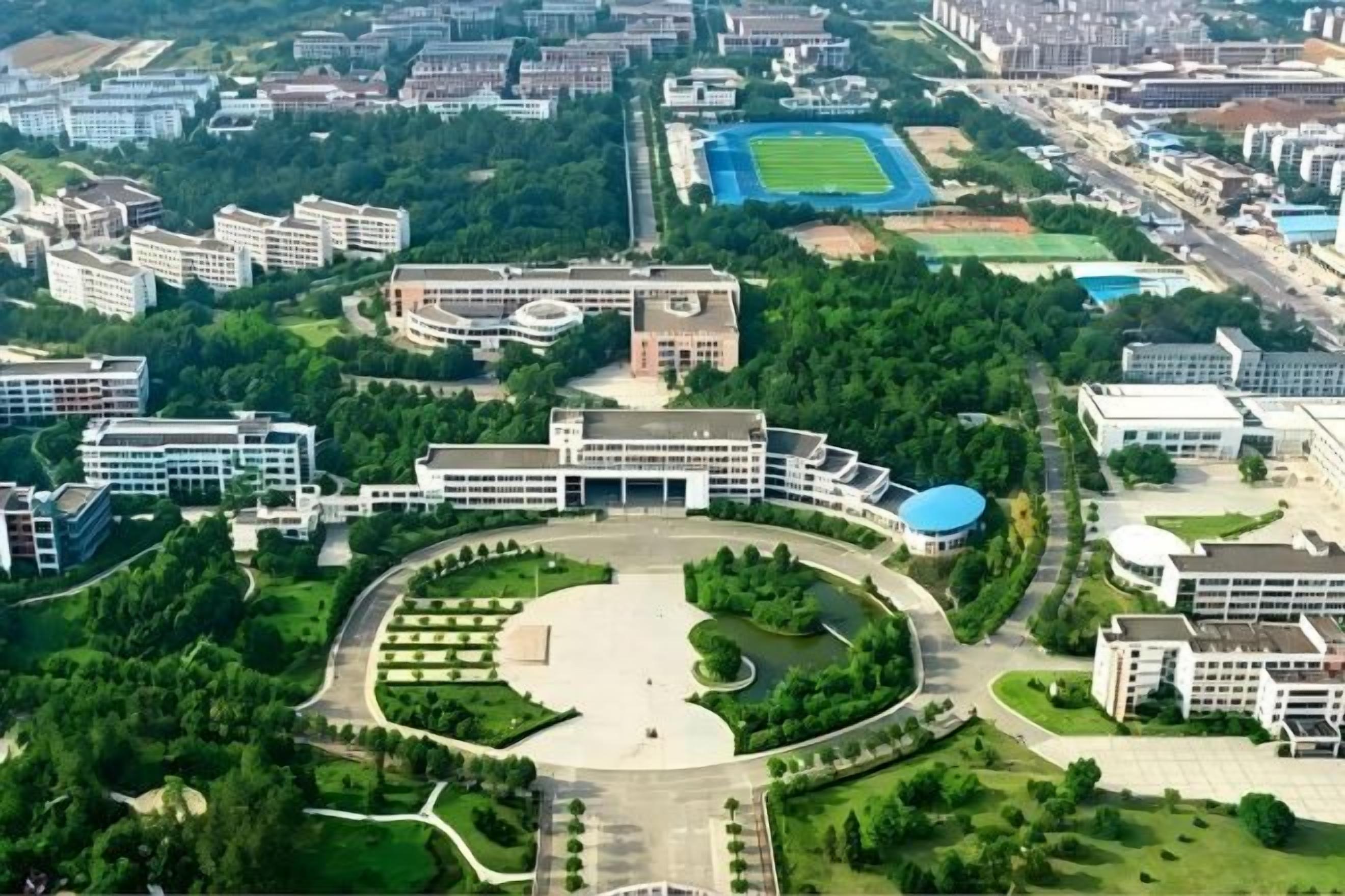 An aerial view of a campus with multiple buildings, a central courtyard, and surrounding greenery.
