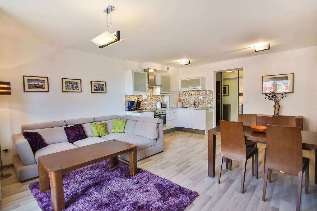 Ein modernes Wohnzimmer mit einer Couch, einem Couchtisch und einem Essbereich.