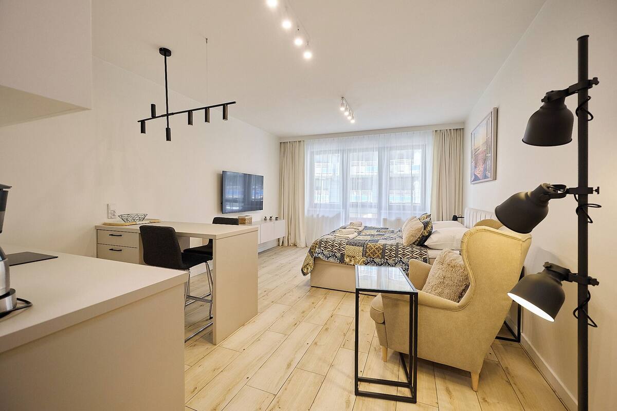 Ein modernes Hotelzimmer mit Bett, Schreibtisch, Stuhl und einem großen Fenster.