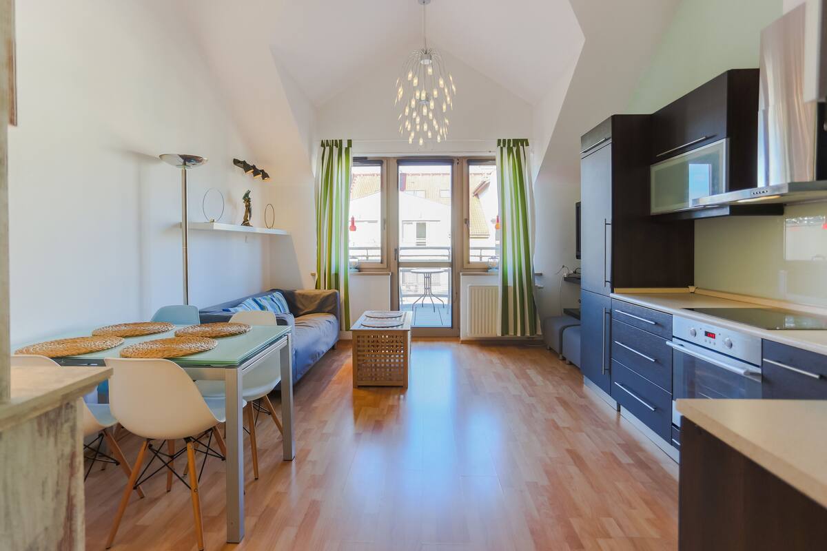 Eine moderne Küche mit Mikrowelle, Backofen und Essbereich mit Tisch und Stühlen.