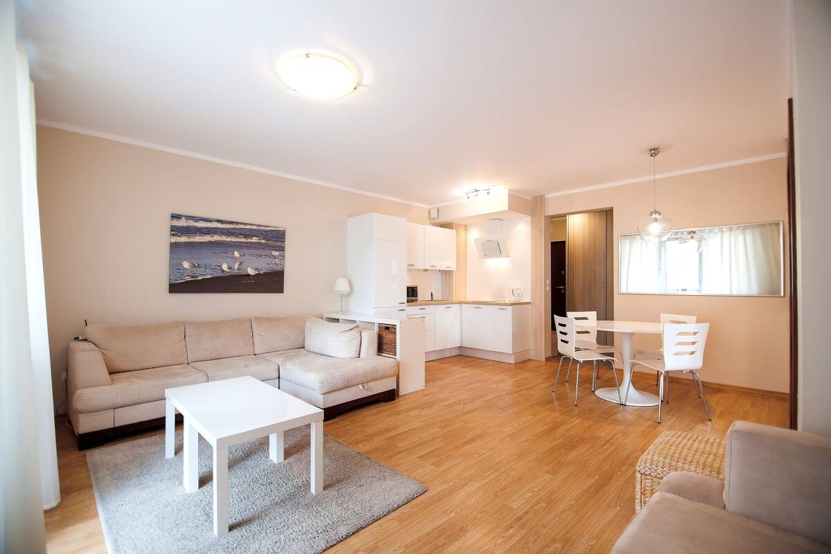 Ein modernes Wohnzimmer mit Sofa, Couchtisch und Essbereich.