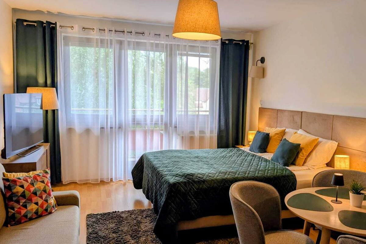 Ein Hotelzimmer mit Bett, Fernseher, Schreibtisch und Stuhl.
