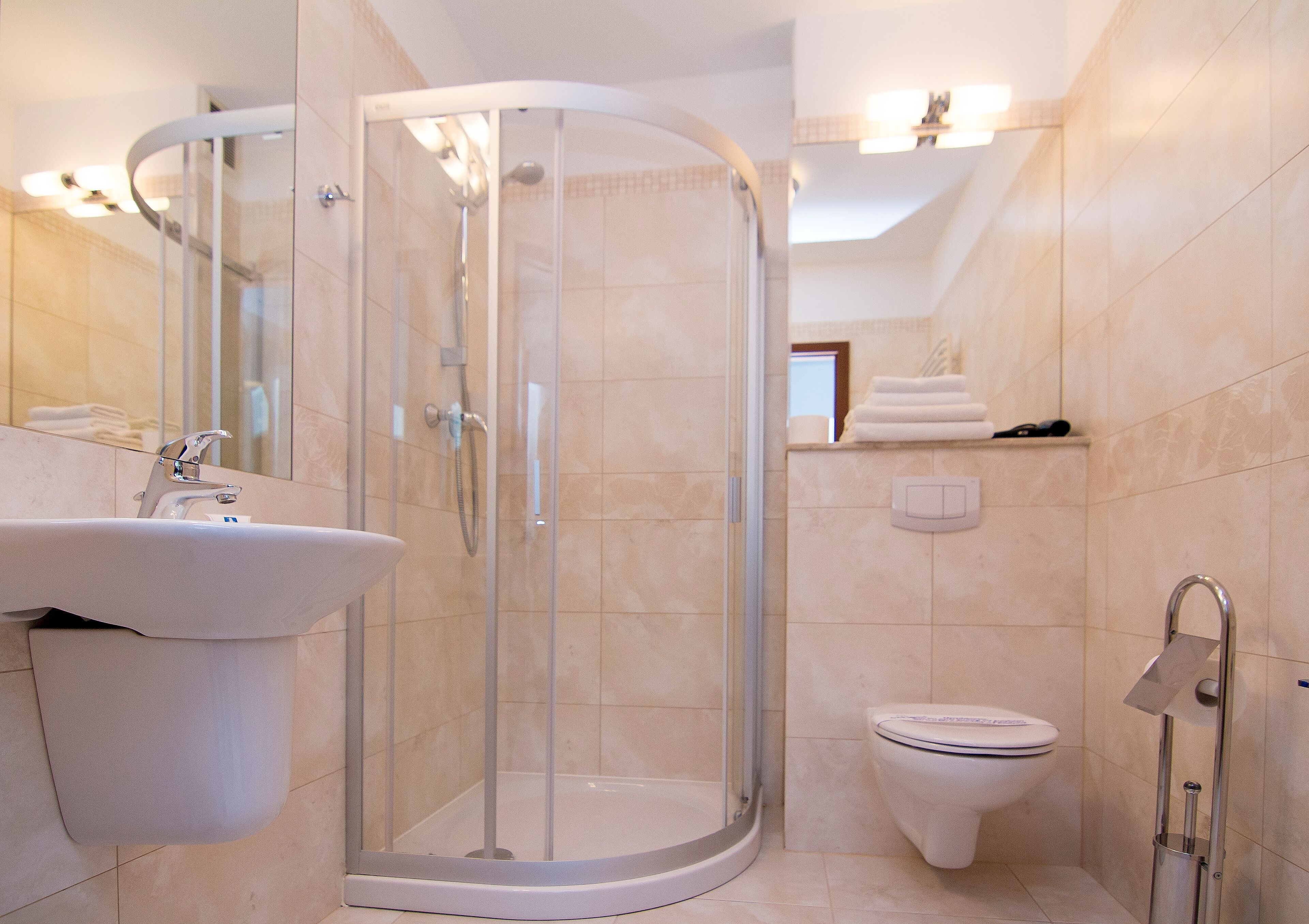 Un bagno moderno con doccia vetrata, lavandino e servizi igienici.