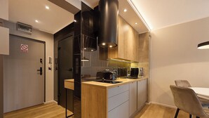 A modern kitchen with a wooden countertop, built-in appliances, and a dining area with a chair.