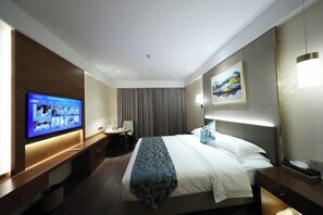 A hotel room with a bed, a desk, a television, and a painting on the wall. - GEM Hotel (Jianhu Ouboliya Zunyuan) (Jianhu)