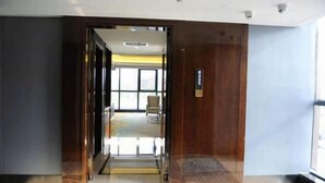 Un hall d’hôtel avec une porte vitrée donnant accès à une chambre.