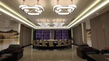 A spacious dining area with a long table, modern lighting fixtures, and comfortable seating.