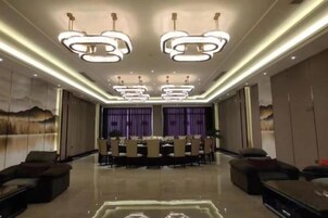 A spacious dining area with a long table, modern lighting fixtures, and comfortable seating.