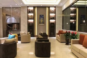 Een moderne lobby met zitgedeeltes, een receptiebalie en een groot raam.