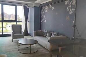 Una sala moderna con sofá, sillón, mesa de centro y una mesita de vidrio.