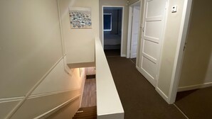 A hallway with a staircase leading to a bedroom. - Lovely 2-bed Apartment in Solihull (Solihull)