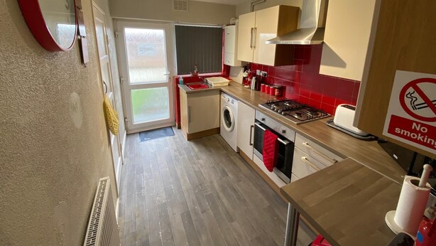 A compact kitchen with a sink, stove, and oven. A 'No Smoking' sign is visible on the wall. - Lovely 2-bed Apartment in Solihull (Solihull)