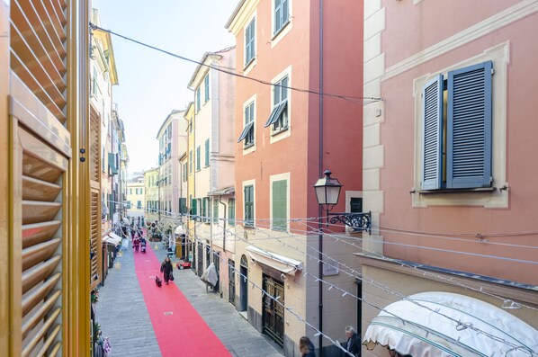 A narrow street with buildings on either side, a red carpet, and a few pedestrians. - Designer Apartment (Rapallo)