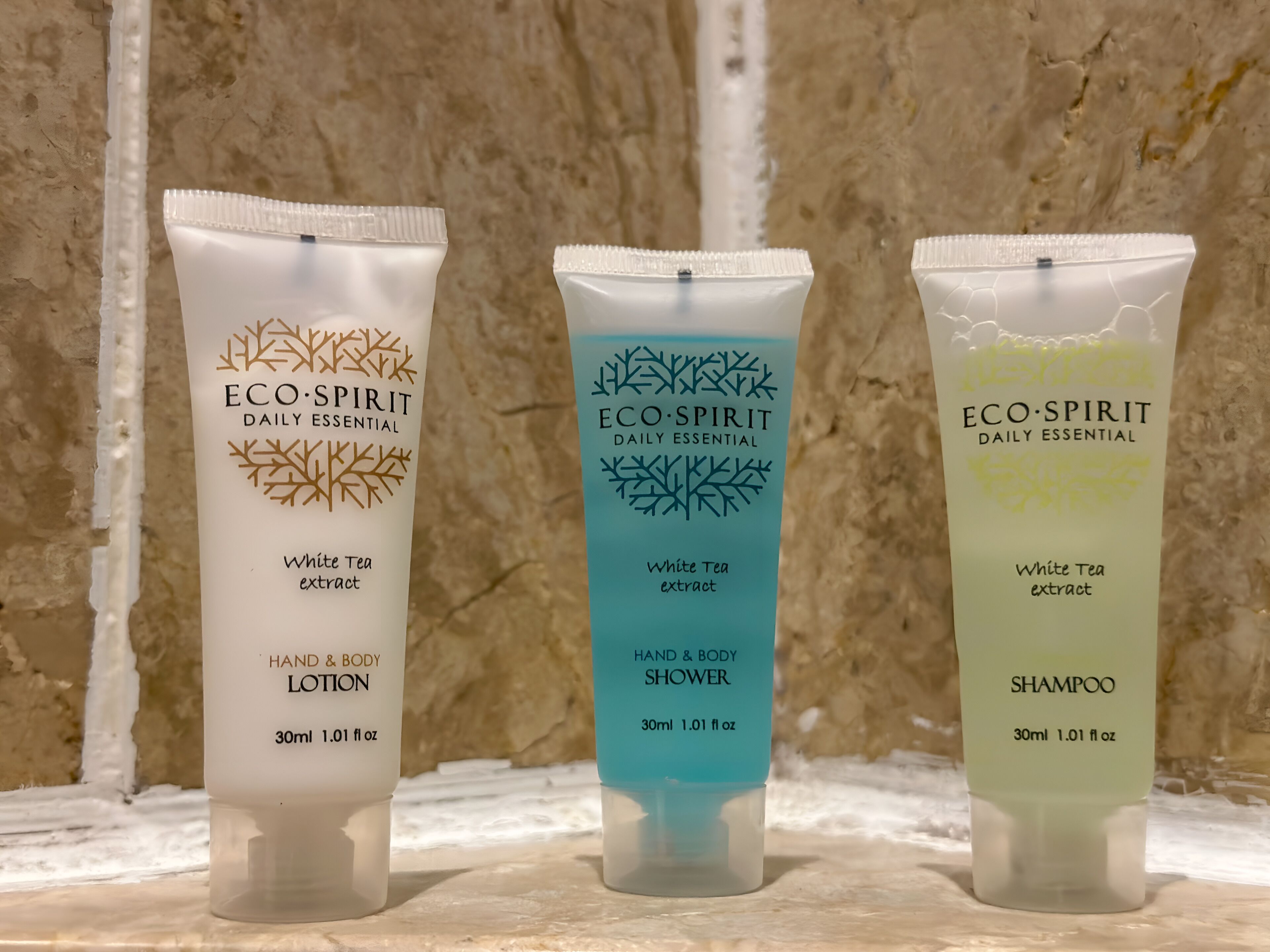 Three bottles of Eco-Spirit Daily Essential products: hand and body lotion, shower, and shampoo.