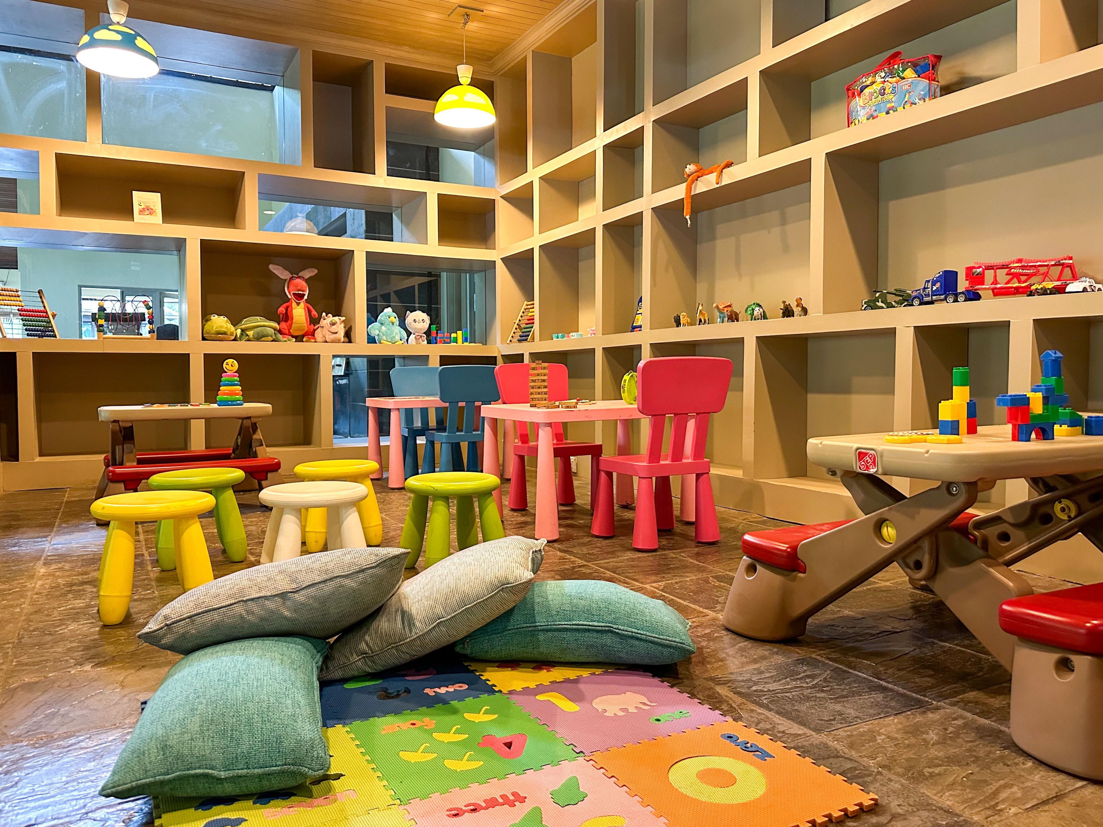 A children's playroom with colorful furniture, toys, and educational materials.