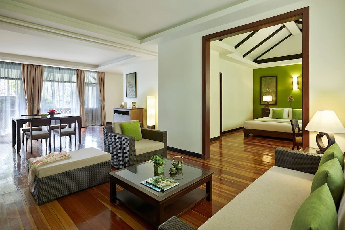 A spacious living area with a sofa, armchairs, a coffee table, and a dining set.