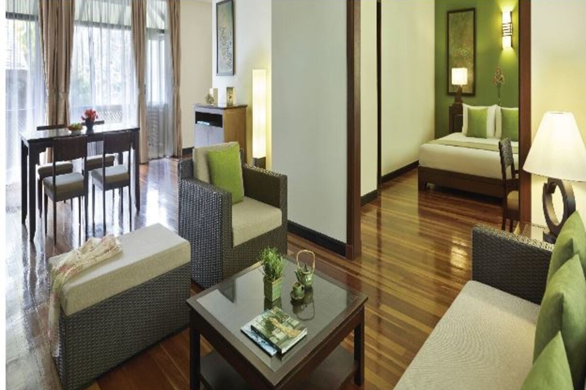 A hotel room with a living area, a dining table, and a sofa.