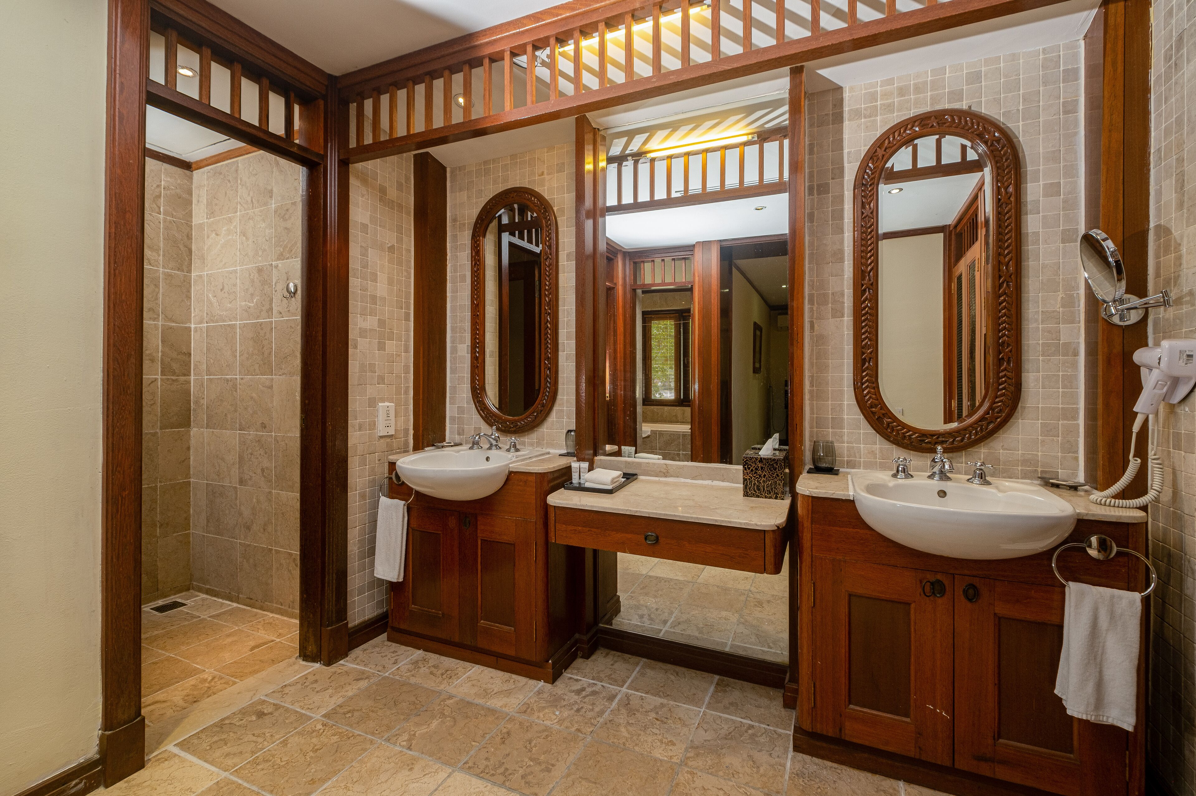 A bathroom with two sinks, wooden cabinets, and a large mirror.