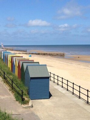 A beach with colorful beach huts and a clear sky. - 4 bed cottage with hot tub and 10 minute walk to beach (Bacton)