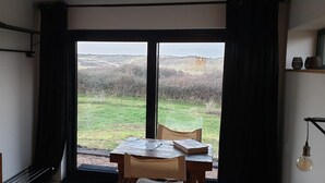 A room with a large sliding glass door leading to a grassy outdoor area. - Impeccable Studio in Ouddorp 400m From th (Ouddorp)