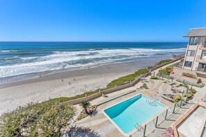 A beachfront hotel with a swimming pool, a beach, and ocean views.