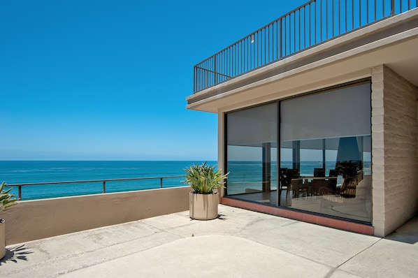 A modern building with a balcony overlooking the ocean.