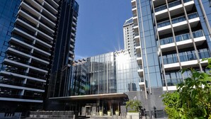 Un edificio moderno con fachadas de vidrio reflectante y una entrada central con marquesina.