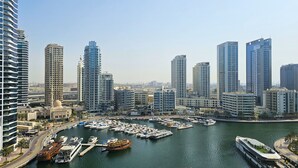 Una marina con numerosos barcos amarrados, rodeada de edificios altos.