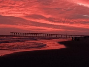 Un muelle se adentra en el agua bajo un cielo al atardecer.