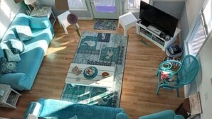 A living room with a sofa set, a coffee table, a TV, and a ceiling fan. - 1 Galway Girl 3 Bedroom Home by RedAwning (Supply)