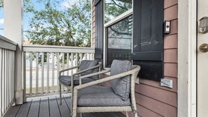 A porch with wicker chairs and a doorbell. - Summer Bliss | Walk to Beach • Master Suite • Bunk Beds • Sleeps 9 (Galveston)
