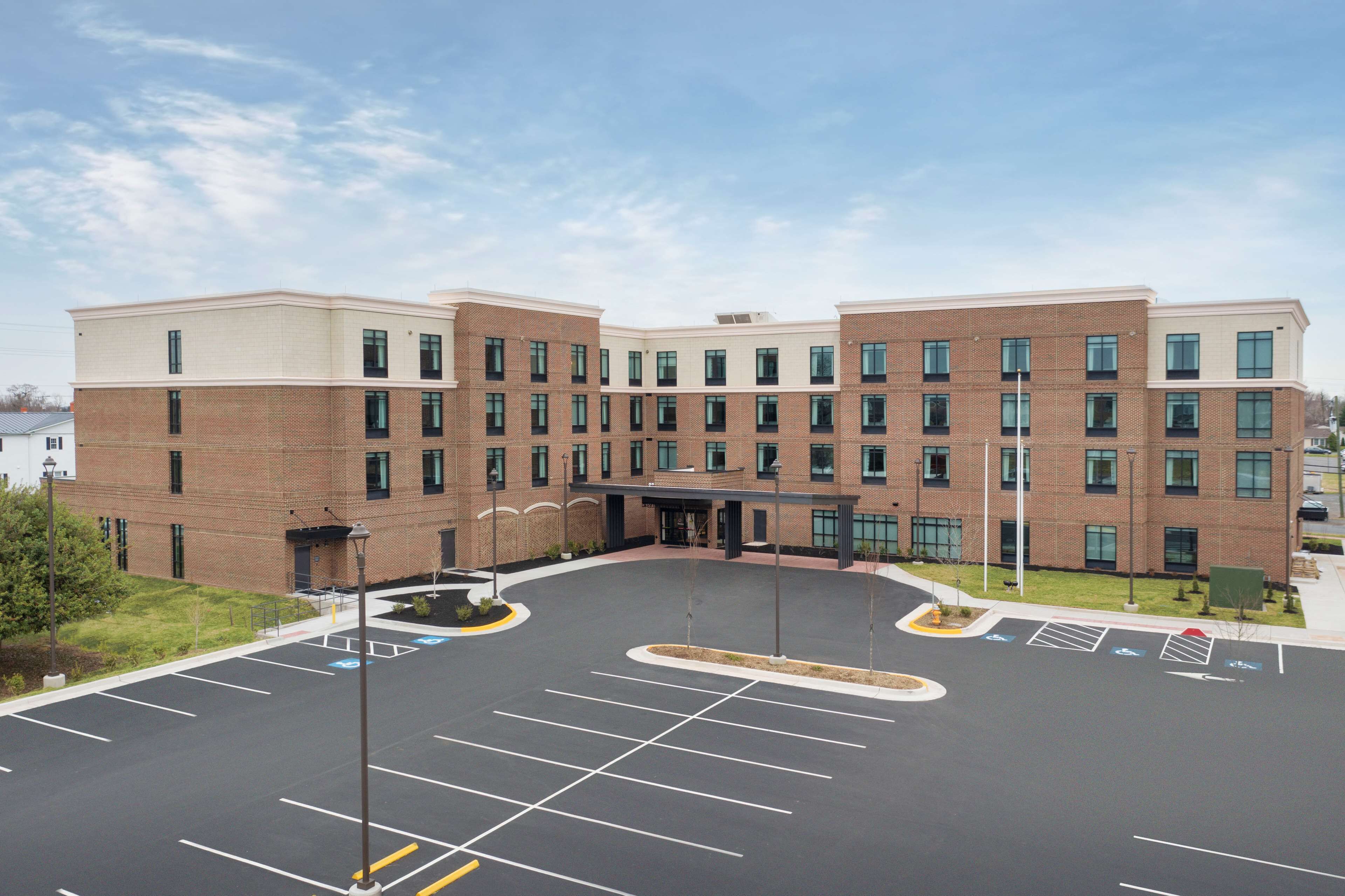 A multi-story building with a parking lot in front.