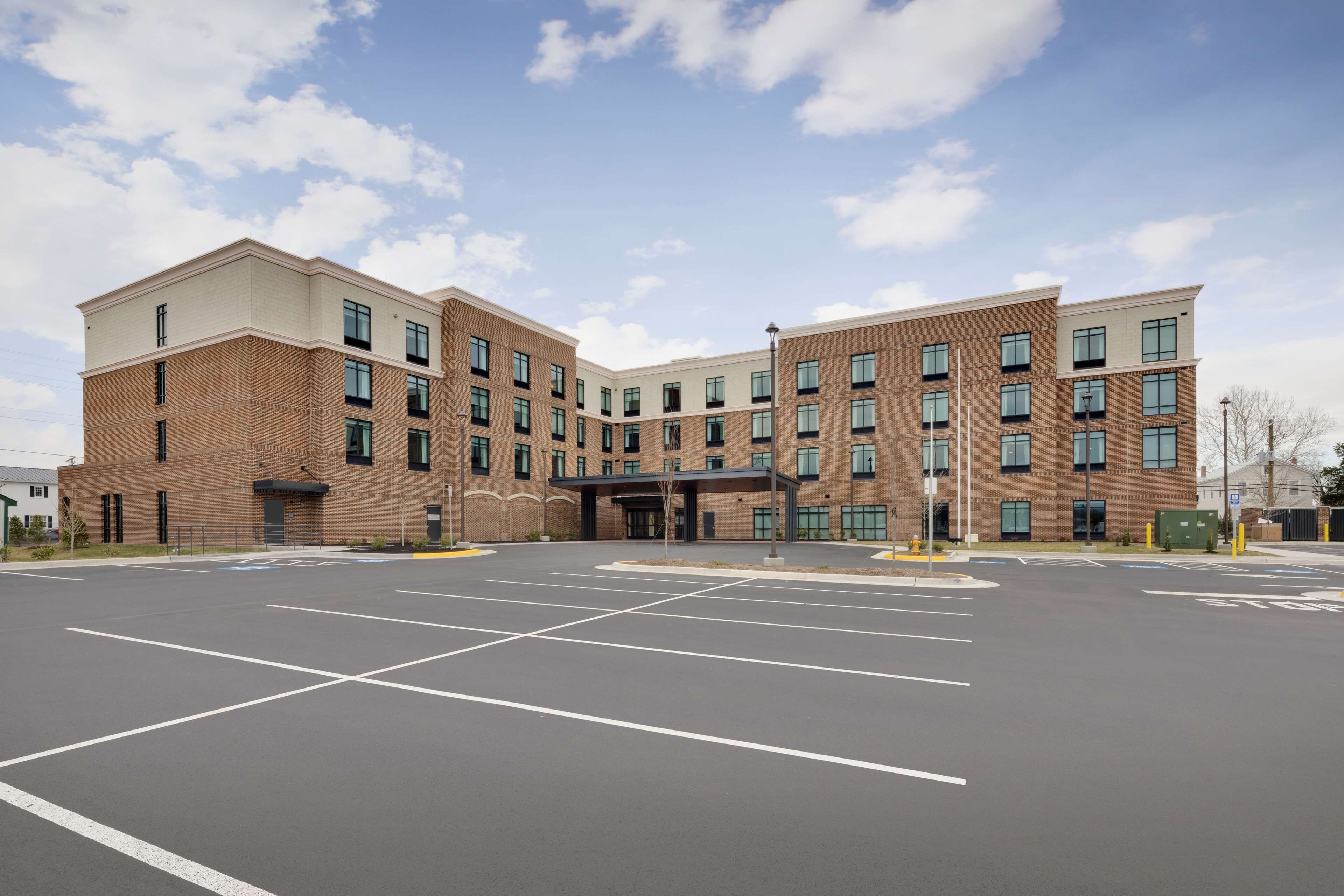 A multi-story building with a parking lot in front.
