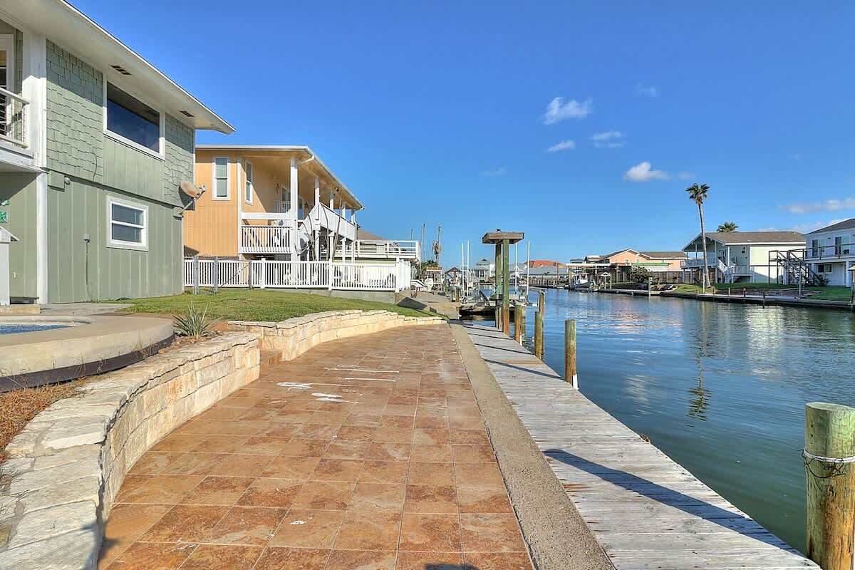 A waterfront property with a paved walkway, a dock, and a marina.