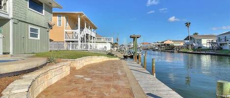 A waterfront property with a paved walkway, a dock, and a marina.