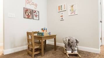 Children can play and learn in this vibrant room with a table, chair, and artwork on the walls.