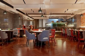 Un intérieur de restaurant moderne avec un plancher en bois, plusieurs tables et chaises.