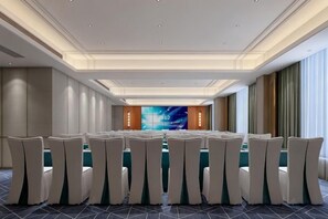 Une salle de conférence dotée d’une longue table et de chaises, d’un grand écran et d’un design de plafond moderne.